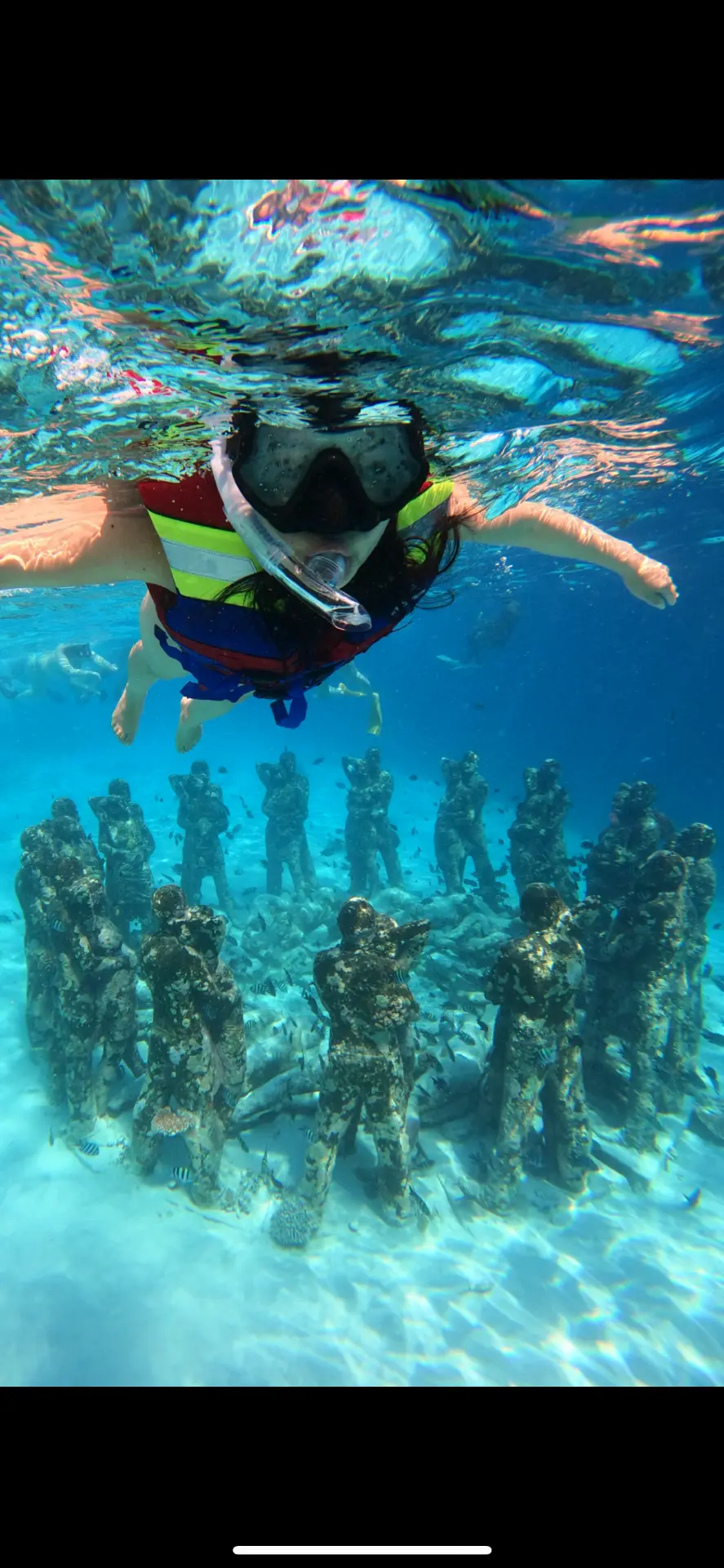 Snorkeler floating above the underwater statues at the Gili Islands