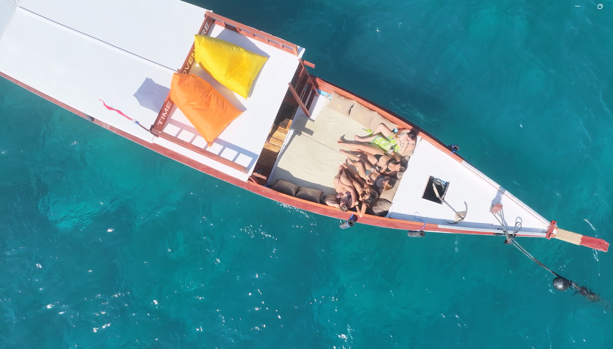 Aerial view of the Jasper boat with guests relaxing on the deck in clear blue water